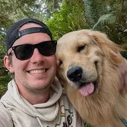 Cody outdoors in sunglasses with his golden retriever, Ripley